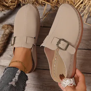 Detail of beige women's wedge clogs featuring adjustable metal buckle strap