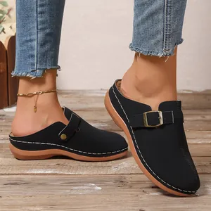 Side view of black closed-toe wedge clogs with buckle and contrast stitching details
