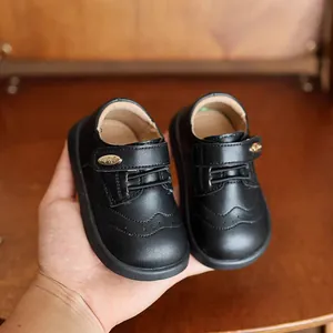 Vista dettagliata di scarpe in pelle nera per bambini, stile inglese e suola morbida.