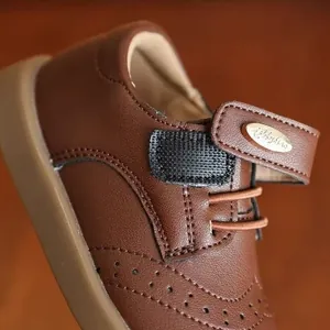 Classic brown girls' leather shoes with brogue detail and soft sole