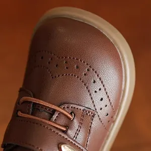 Detailed macro view of brown girls brogue leather shoes with decorative holes