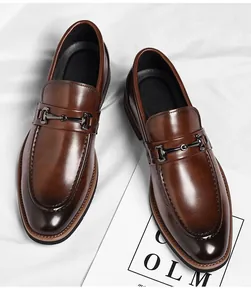 Detailed top-down view of classic brown leather horsebit loafers on white fabric background