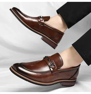 Close-up of elegant brown men's leather loafers with stylish metal bit decoration.