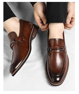 Close-up of men's brown leather loafers with horsebit detail and polished finish.