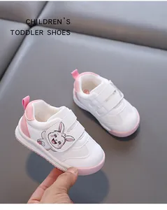 Detail showing white toddler walking shoes with a cute pink cartoon rabbit and velcro straps
