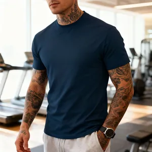 Close-up of a slim-fit navy blue athletic t-shirt on a muscular man in a gym setting.