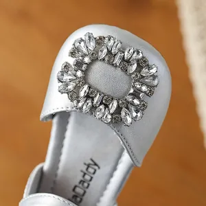 Close-up of silver girl's princess shoe featuring a sparkling rhinestone square buckle detail