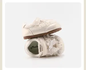 Close-up detail of cream baby girl shoes featuring lace trim and bow decoration
