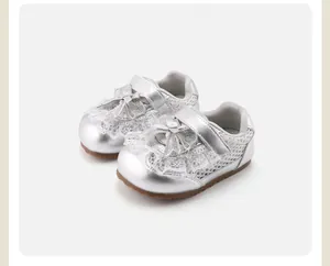 Silver metallic baby girl shoes featuring delicate lace trim and a cute bow detail.