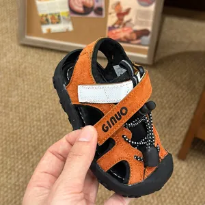 Vista dettagliata del sandalo sportivo per bambini in camoscio marrone con logo Ginuo