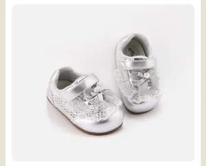 Close-up of silver baby girl sneakers with lace bow and flower detail