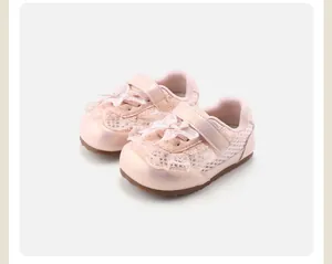Close-up of pink girl's non-slip baby shoes with lace and bowknot details