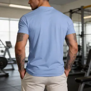 Back view of men's blue quick-dry fitness T-shirt in a professional gym setting.