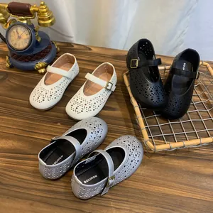 Vue détaillée de ballerines Mary Jane ajourées et respirantes en blanc, noir et argent.