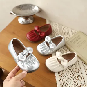 Détail de la chaussure Mary Jane argentée pour fille avec un joli nœud plissé élégant.