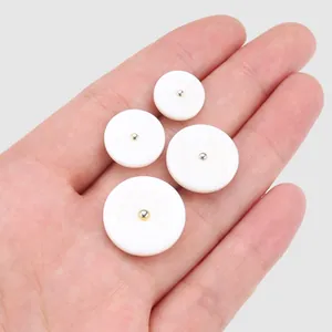 Four white mother of pearl shell buttons in various sizes for high-end fashion apparel.
