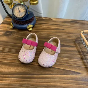 Detailed macro view of sparkly pink Mary Jane shoes for girls with vibrant pink bows