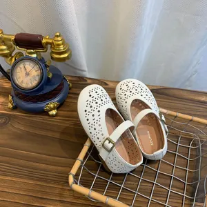 Vue détaillée de chaussures plates Mary Jane blanches avec motifs ajourés