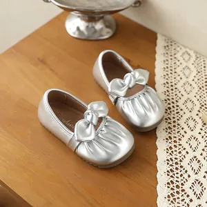 Vue détaillée de chaussures Mary Jane argentées pour filles avec nœud et plissage.