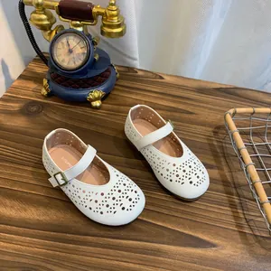 Détail de chaussures plates Mary Jane blanches ajourées et respirantes avec bride