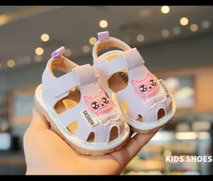 Close-up detail of cute purple baby walker sandals with a cartoon cat and soft sole