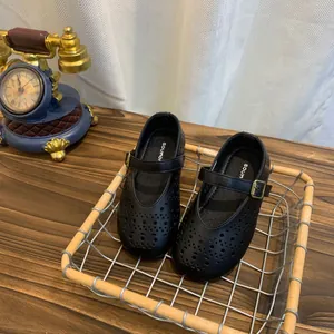Détail de chaussures plates Mary Jane noires évidées dans un panier en fil rustique.