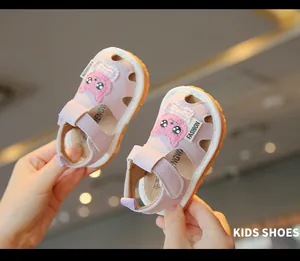 Detailed view of pink toddler sandals with a cute cartoon cat patch and soft soles.