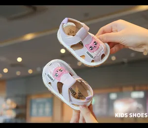 Detail of purple infant sandals with cute cartoon cat patch for toddlers.