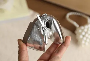 Macrodetail van flexibele zilveren baby prinsessenschoen met elegante parel strik decoratie