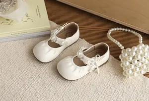 Detail van crème prinsessenschoenen voor meisjes met parelbandjes en chique ruches