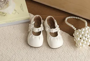 Gedetailleerde weergave van elegante crème prinsessenschoenen voor meisjes met parels