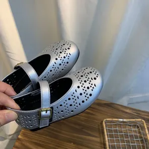Détail de chaussures Mary Jane argentées avec motifs ajourés respirants au laser
