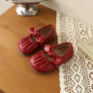 Détail de chaussures Mary Jane rouges pour filles avec nœud doux et plis élégants
