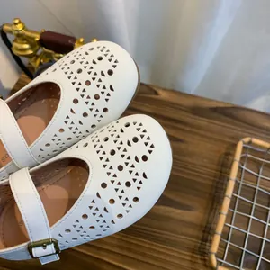 Détail des chaussures plates Mary Jane blanches ajourées et respirantes à bout rond
