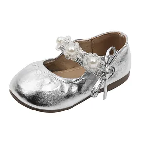 Glanzende zilveren prinsessenschoenen voor meisjes met parels en strik op wit decor.