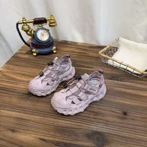 Close-up of lavender breathable mesh children's sports sandals on a vintage wooden table