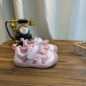 Detailweergave van roze peutersneakers op een houten tafel met vintage decoratie