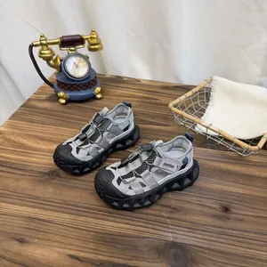 Breathable grey mesh children's sports sandals displayed on a rustic wooden table