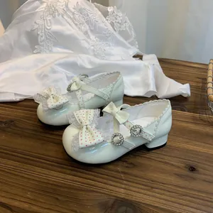 Detalle de zapatos de princesa Lolita crema con lazos y encaje para niñas.