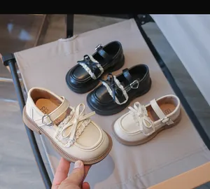 Detailansicht von schicken Mädchen-Prinzessin-Lederschuhen mit Spitzenschleifen und Herzschnallen.