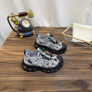 Detailed view of breathable grey mesh sports sandals for kids on a wooden surface