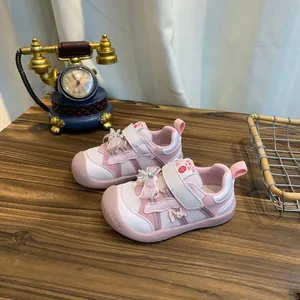 Roze peutersneakers met schattig strikje en klittenbandsluiting op houten tafel