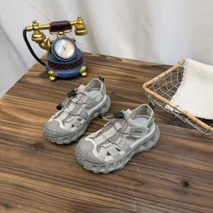 Grey breathable mesh kids' sports sandals with thick non-slip soles and toggle closure.