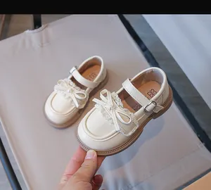 Detailansicht beige Mädchen Mary Jane Schuhe mit eleganter Schleife und Spitze.