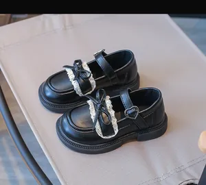 Detailansicht schwarze Mädchen-Mary-Janes mit Schleife und Herzschnalle