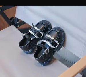 Detailansicht der schwarzen Prinzessinnenschuhe für Mädchen mit Spitze und Schleife