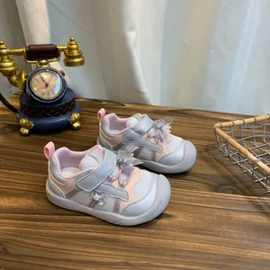 Detailopname van ademende roze en witte babysneakers met een prachtige decoratieve strik