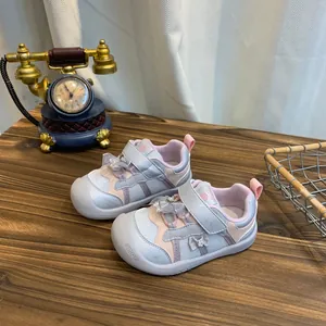 Zijaanzicht van antislip sportschoenen voor peuters met vlinderdetail op houten tafel