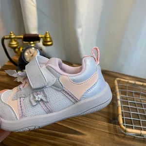 Detailopname van grijze en roze peutersneaker met vlinderdetail en mesh