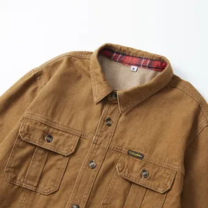 Gros plan de chemise en jean marron avec deux poches poitrine et col à carreaux
